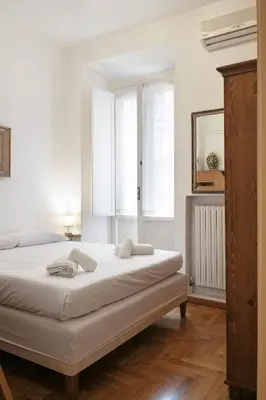 a bedroom with a bed and a mirror and windows at Trevi Fountain Apartment in Rome