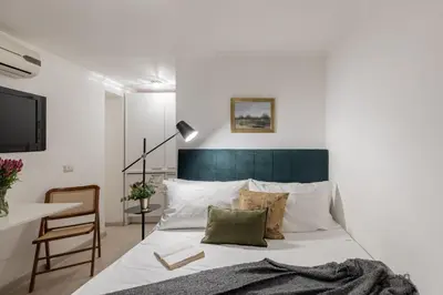 a bedroom with a bed with a green headboard at GuestHost - Basic Studio - 350 m far from Fontana di Trevi in Rome