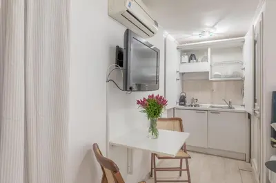 a small kitchen with a table with a vase of flowers on it at GuestHost - Basic Studio - 350 m far from Fontana di Trevi in Rome