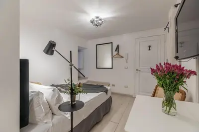 a bedroom with a bed and a table with flowers at GuestHost - Basic Studio - 350 m far from Fontana di Trevi in Rome