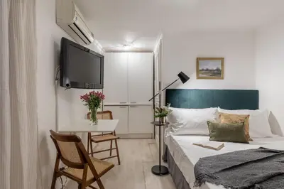 a bedroom with a bed and a table and a tv at GuestHost - Basic Studio - 350 m far from Fontana di Trevi in Rome