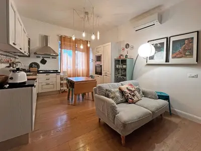 a living room with a couch and a kitchen at Casa Gioia - Metro Garbatella in Rome