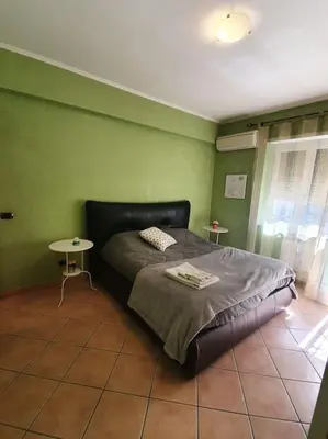 a green bedroom with a bed and a table at A 2 passi dal cuore di Roma in Rome