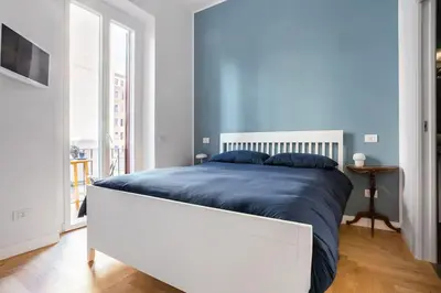 a bedroom with a large bed with blue sheets at La finestra verde in Rome