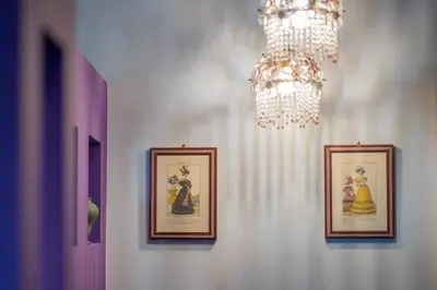 a chandelier and three framed pictures on a wall at PgrHome Colosseo 11 in Rome
