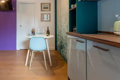 a table and two chairs and a purple wall at PgrHome Colosseo 11 in Rome