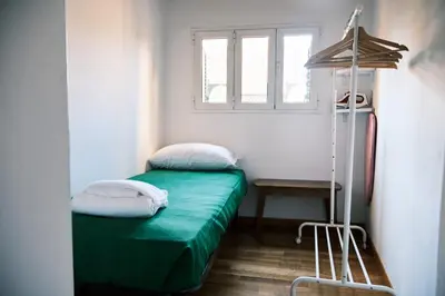 a small room with a green bed and a window at Terrazza San Saba in Rome