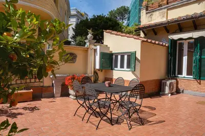 a patio with a table and chairs in front of a house at Terrazza San Saba in Rome