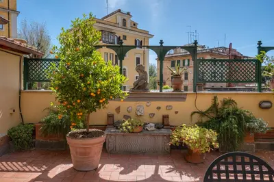 a courtyard with a fountain and trees and buildings at Terrazza San Saba in Rome