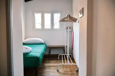 a small room with a green bed and a window at Terrazza San Saba in Rome