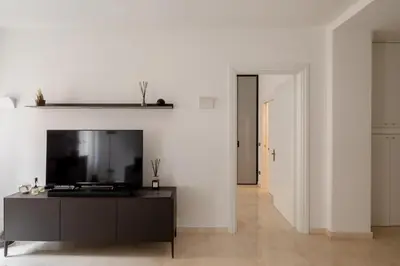 a living room with a tv and a black cabinet at Nostromondo Basilica Apartment in Rome