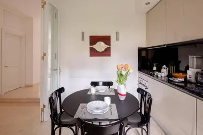 a kitchen with a black table and chairs and a counter at Nostromondo Basilica Apartment in Rome