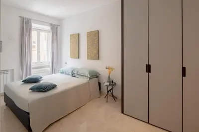 a bedroom with a large bed with blue pillows at Nostromondo Basilica Apartment in Rome