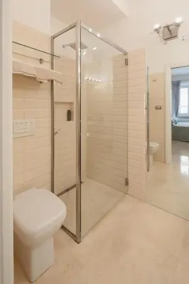 a bathroom with a toilet and a glass shower stall at Nostromondo Basilica Apartment in Rome