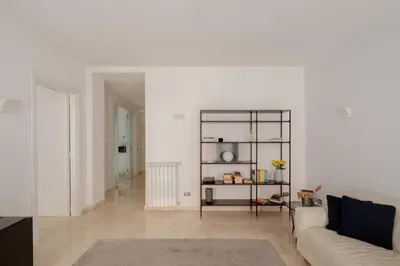 a living room with white walls and a white couch at Nostromondo Basilica Apartment in Rome