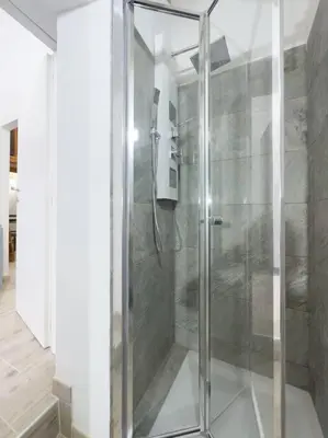 a shower with a glass door in a bathroom at Apartment with Terrace in the Heart of Pigneto in Rome