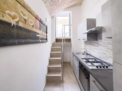 a kitchen with a staircase and a painting of birds on the wall at Apartment with Terrace in the Heart of Pigneto in Rome