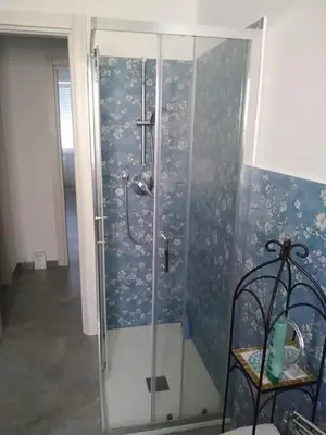 a shower in a bathroom with a blue wall at casaLucina in Rome