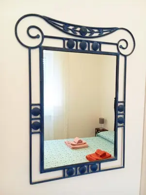 a mirror on a wall with a bed in a room at casaLucina in Rome