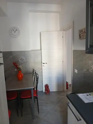 a kitchen with a table and chairs and a clock on the wall at casaLucina in Rome