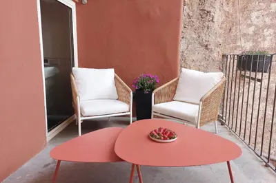 a red coffee table and two chairs on a balcony at YCH Elegant flat with terrace to Trastevere in Rome