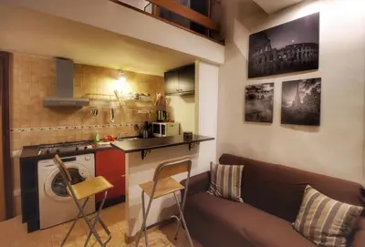 a living room with a couch and a kitchen at Hidden Treasure-Campo de' Fiori in Rome