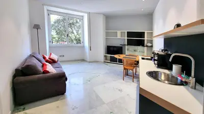 a living room with a couch and a kitchen at Vignola New Apartment in Rome