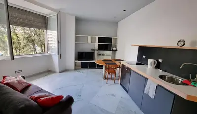 a kitchen and living room with a couch and a table at Vignola New Apartment in Rome