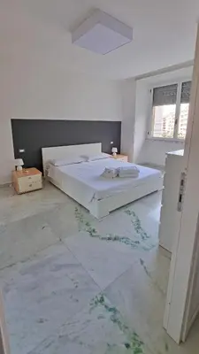 a white bedroom with a bed in a room at Vignola New Apartment in Rome