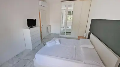 a bedroom with a white bed and a television at Vignola New Apartment in Rome