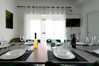 a table with glasses and plates and wine bottles at Home Big Crirè at 724 in Rome