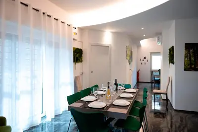 a dining room with a table and green chairs at Home Big Crirè at 724 in Rome