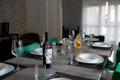 a table with glasses and plates and a bottle of wine at Home Big Crirè at 724 in Rome