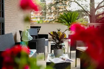 a table with a book and flowers on a patio at Home Big Crirè at 724 in Rome