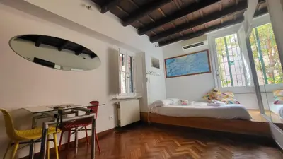 a bedroom with a bed and a table and windows at Vivaldi in Rome