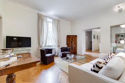 a living room with white furniture and a flat screen tv at Pantheon Exclusive House in Rome