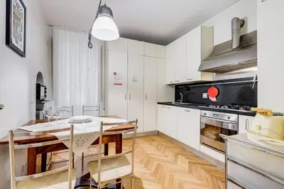 a kitchen with white cabinets and a dining table at Pantheon Exclusive House in Rome