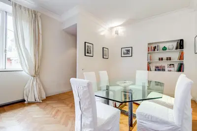 a dining room with a glass table and white chairs at Pantheon Exclusive House in Rome