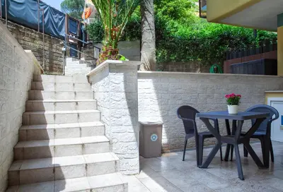 a patio with a table and chairs and stairs at Garden City House Roma - Casa con giardino privato in Rome