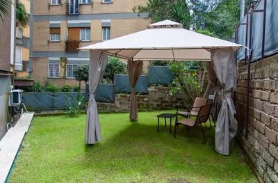an umbrella in a yard with a table and chairs at Garden City House Roma - Casa con giardino privato in Rome