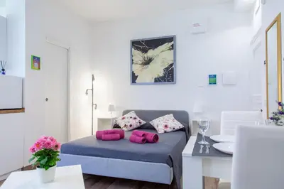 a bedroom with a bed with pink pillows on it at Garden City House Roma - Casa con giardino privato in Rome