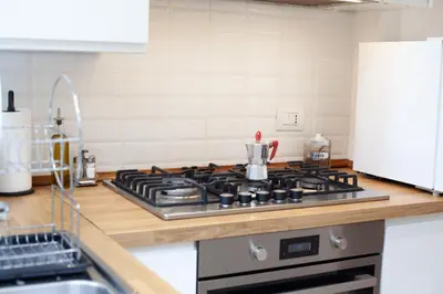 a kitchen with a stove top oven in a kitchen at Garden City House Roma - Casa con giardino privato in Rome