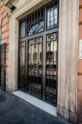 a building with black doors with a clock on it at Francesco Romestay - Termini in Rome