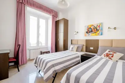 a hotel room with two beds and a window at Francesco Romestay - Termini in Rome