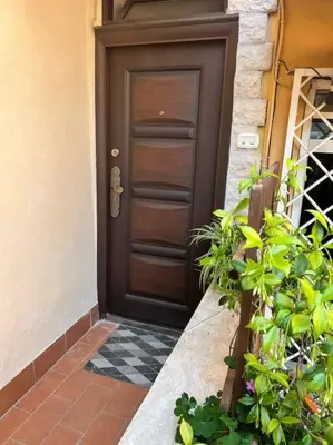 a wooden door on a house with some plants at Monolocale San Giovanni in Rome