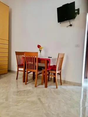 a dining room table with four chairs and a television at Monolocale San Giovanni in Rome