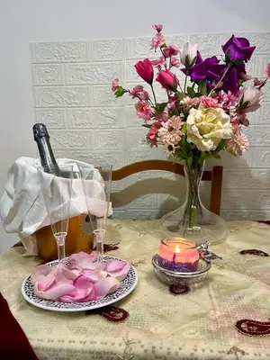 a table with a bottle of wine and a vase of flowers at Monolocale San Giovanni in Rome