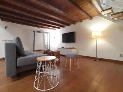 a living room with a couch and a table and a tv at La Dimora Dante in Rome