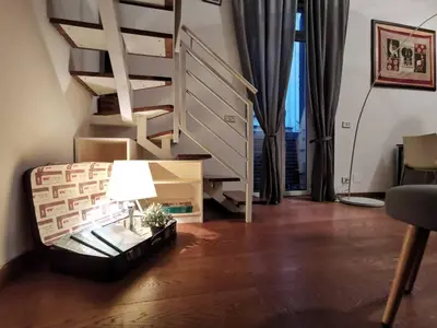 a living room with a staircase and a table with a lamp at La Dimora Dante in Rome