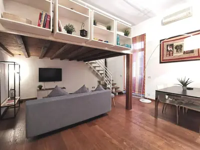 a living room with a gray couch and a staircase at La Dimora Dante in Rome